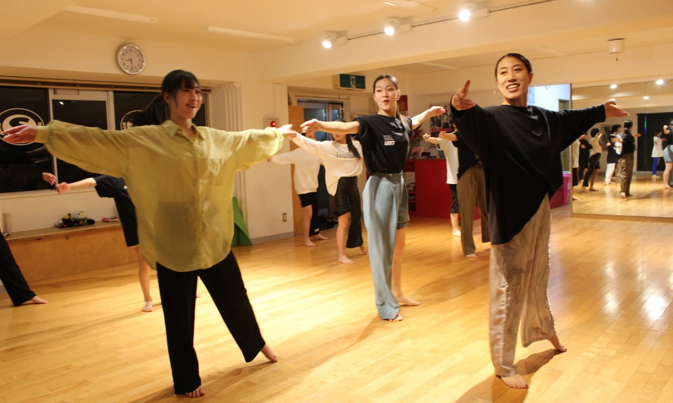 手を広げて踊る3人の女性