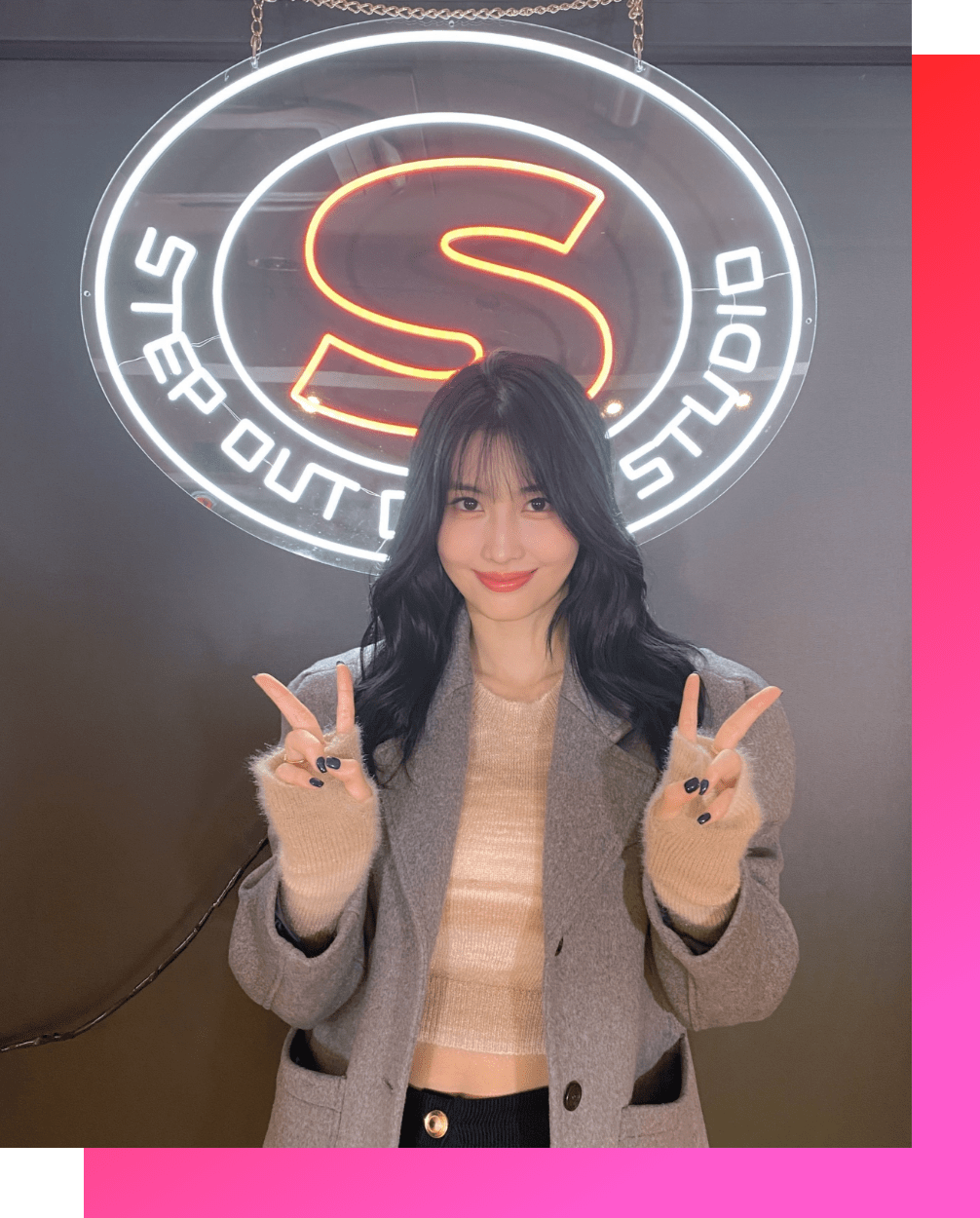 ネオンサインの前でVサインをするTWICEのMOMO