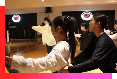 先生にサポートされて鏡の前で踊る女の子